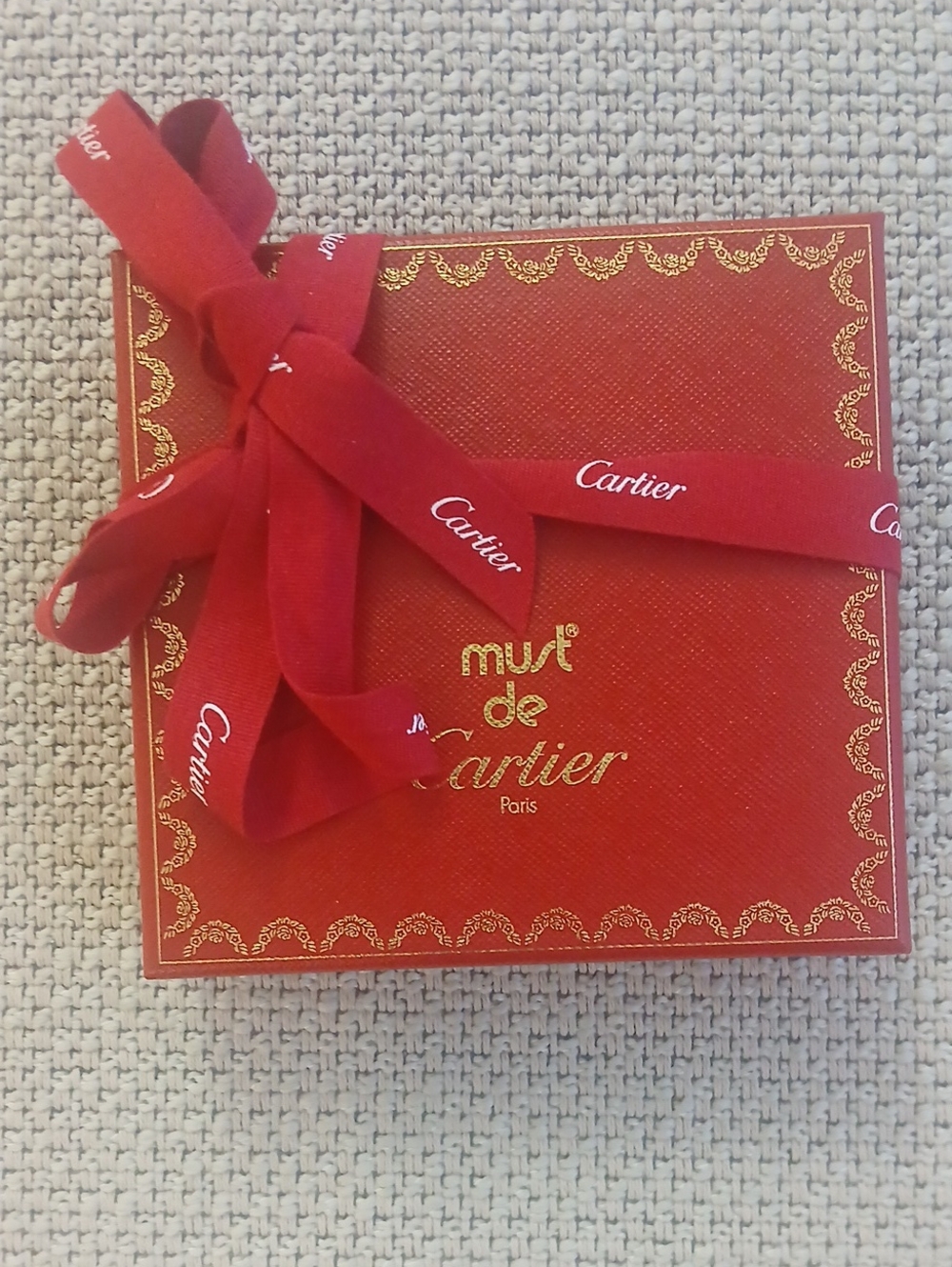 Cartier red box with gold trim and ribbon